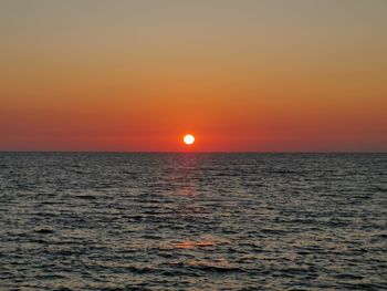 Scenic view of sea against orange sky