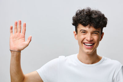 Portrait of young man gesturing against white background