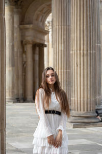 Portrait of woman standing against colonnade
