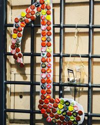 Close-up of multi colored decoration hanging on railing against wall