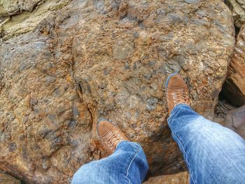 Low section of man standing on rock