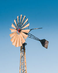 Low angle view of traditional windmill against clear blue sky