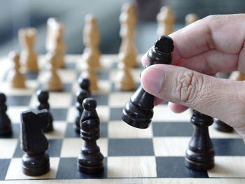 Close-up of hand holding chess piece