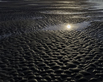 High angle view of wet sand at beach against sky
