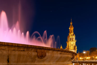 Panoramic view of illuminated building against sky at night
