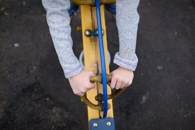 Cropped hands of girl on spring ride in playground