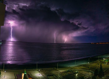 Scenic view of sea against cloudy sky at night