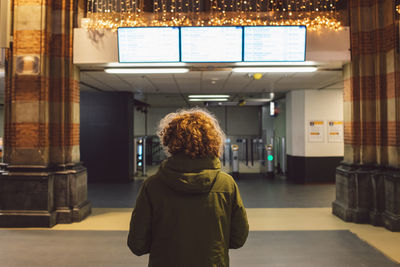Rear view of woman standing in train station 