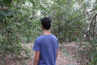 Boy standing in forest