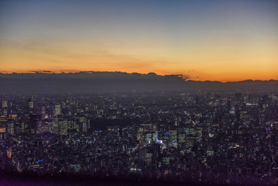 High angle view of illuminated cityscape against sky during sunset