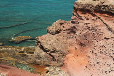 High angle view of rock formation at beach against sky