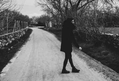 Rear view of woman walking on footpath