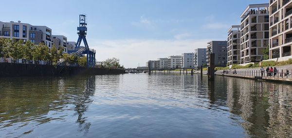 River by buildings in city against sky