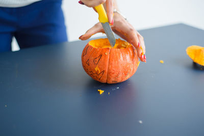 Woman carving pumpkin for halloween at home