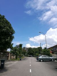 Cars on road against sky in city