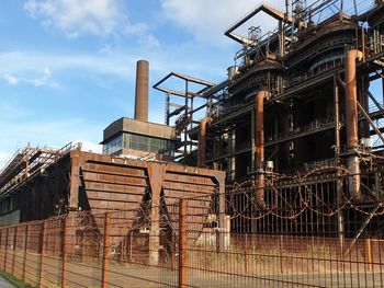 Low angle view of built structure against sky abandoned factory rust iron