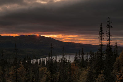 Scenic view of silhouette mountains against orange sky