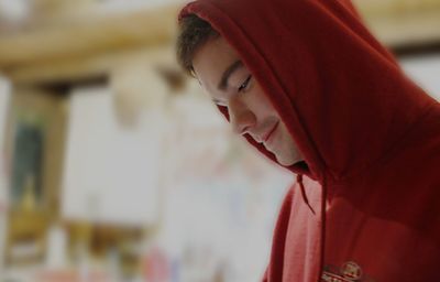 Close-up of smiling young man wearing hooded shirt