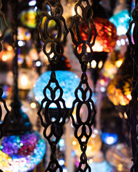 Close-up of illuminated lanterns hanging at market stall