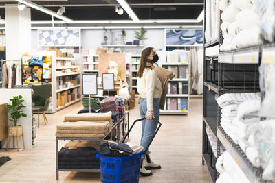 Young woman wearing face mask and protective gloves in store. today people lifestyle concept