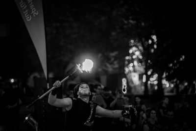 People holding illuminated stage at night