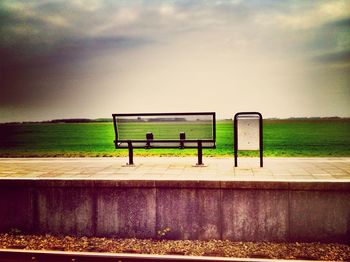Scenic view of grassy field against cloudy sky