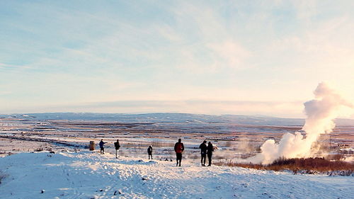 People on beach against sky during winter