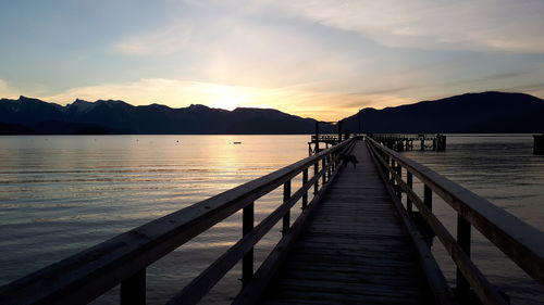 Pier over sea against sky during sunset