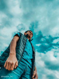 Low angle view of man relaxing against sky