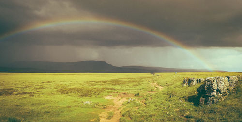 Scenic view of rainbow over mountain against sky