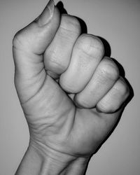 Close-up of baby hand over white background