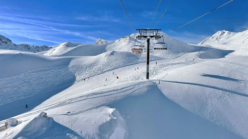 Ski lift and ski slopes in beautiful snowy mountains under blue sky at tignes resort france