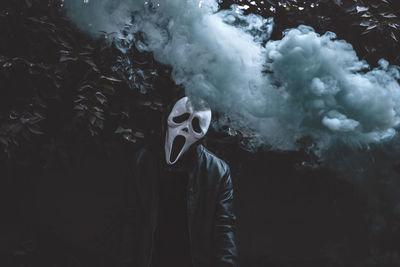 Midsection of person wearing mask standing on rock