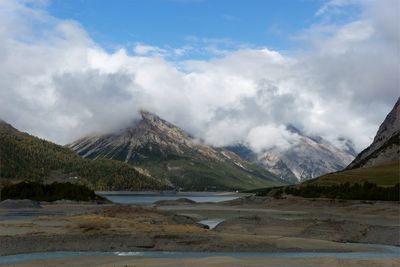 Scenic view of lake by mountains against sky