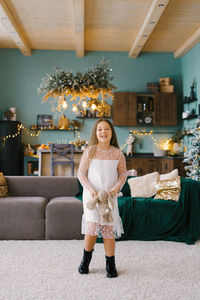 A girl has fun with a stuffed toy in the living room, decorated for christmas