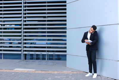 Full length of young man using mobile phone