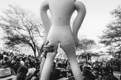 Rear view of people standing against trees