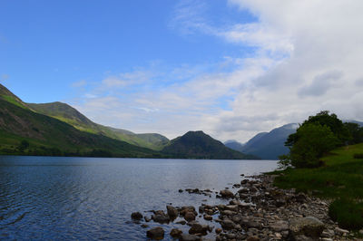 Scenic view of lake by mountains against sky