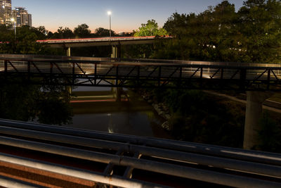 Railroad tracks by bridge against sky