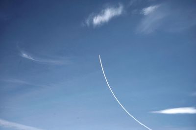 Low angle view of vapor trail in blue sky