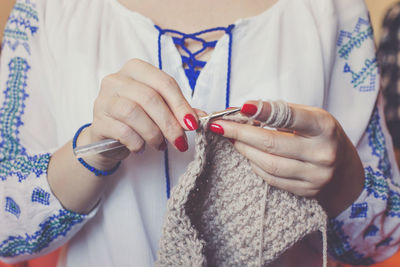 Midsection of woman knitting wool