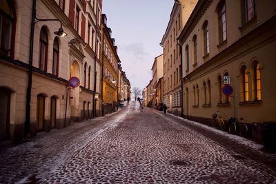 Road amidst buildings against sky