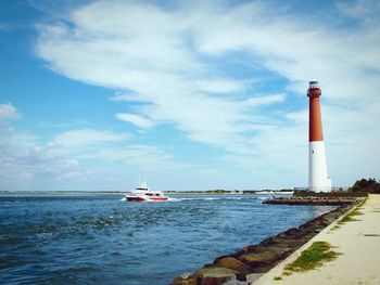 Lighthouse in sea against sky