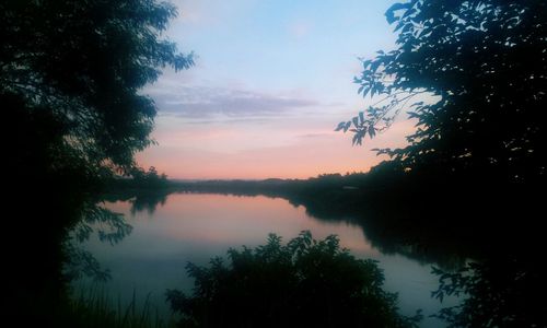 Scenic view of lake against sky at sunset