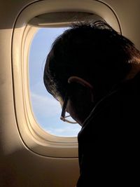 Portrait of man looking through airplane window