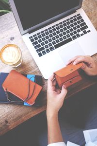 Cropped hands of businessman opening wallet on table