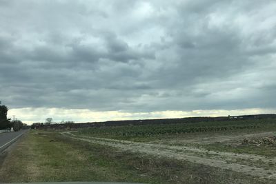 Scenic view of field against storm clouds