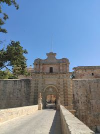 Low angle view of old building against clear blue sky