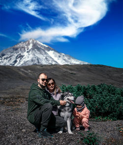 Full length of man with dog on mountain against sky