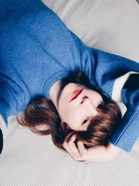 High angle view of young woman sleeping on bed at home